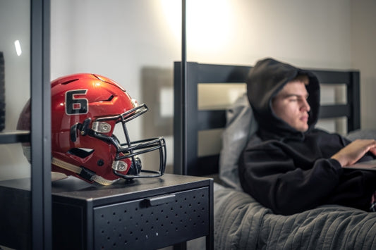 teenager-guy-sits-room-bed-uses-laptop